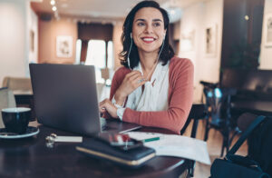 Businesswoman with laptop and headphones working in cafe